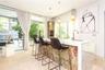 Kitchen island featuring a waterfall countertop with a stone-finish side panel and built-in cabinetry, polished stone flooring, and suspended pendant 