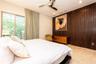 Room featuring floor-to-ceiling wood-panelled accent wall, stone-finish tile flooring, recessed lighting, and sliding glass doors with louvered window