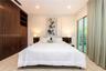 Room featuring floor-to-ceiling wood-grain cabinetry, stone flooring, recessed lighting, and sliding glass doors with louvered panels