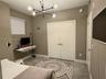 Room featuring neutral wall paint, tile flooring, a multi-arm sputnik-style chandelier, and double-door closet storage