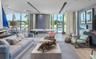 Floor-to-ceiling glass walls, recessed linear lighting, textured wall treatments, wood-finish flooring, and built-in shelving unit