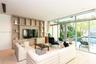 Floor-to-ceiling sliding glass doors, custom wood-finish floor-to-ceiling built-in cabinetry, recessed lighting, and stone flooring
