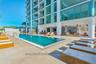 Rectangular swimming pool with integrated entry steps and light-toned stone pool deck