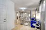 Large-format stone-tile flooring, decorative textured wall finish, and polished chrome multi-light chandeliers