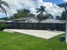 Backyard featuring a raised concrete patio and a dark-toned privacy fence