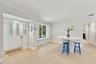 Entryway featuring a white door with decorative glass panels, neutral tile flooring, recessed lighting, crown molding, and window shutters