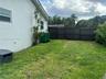 Rear exterior featuring a smooth stucco finish and a dark-toned vertical privacy fence