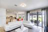 Open-concept interior featuring large-format stone flooring, recessed lighting, kitchen with light-toned cabinetry, and floor-to-ceiling sliding glass