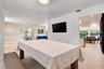 Neutral-toned interior featuring recessed lighting, smooth-finish ceiling, crown molding, and large-format tile flooring