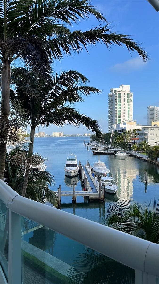 Waterfront terrace with a white powder-coated aluminum railing, featuring a boat dock and expansive water frontage