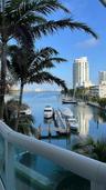 Waterfront terrace with a white powder-coated aluminum railing, featuring a boat dock and expansive water frontage
