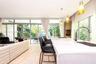 Kitchen island featuring a waterfall-edge stone countertop, undermount sink, and chrome gooseneck faucet, complemented by floor-to-ceiling glass panel