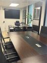 Built-in dark-toned cabinetry, integrated cable management desk systems, recessed lighting, and tile flooring