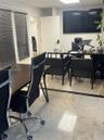 Stone flooring with decorative inlay, inset wall-mounted display screen, and window treatments with horizontal blinds