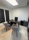 Office featuring stone tile flooring, dual windows with fitted blinds, and a recessed ceiling panel