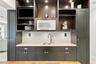 Built-in cabinetry featuring dark finish, recessed task lighting, integrated microwave, stone-finish countertop, and undermount stainless steel sink w