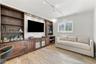 Built-in wall-to-wall cabinetry featuring dark wood finish, open shelving, lower storage drawers, and recessed lighting, finished with wood-finish flo
