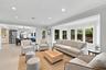 Open-concept space featuring oversized bay windows, neutral tile flooring, recessed lighting, and crown molding