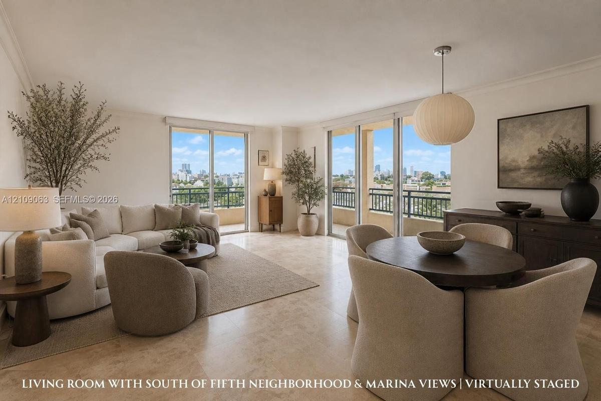 Open-concept interior featuring light-toned stone tile flooring, dual floor-to-ceiling glass sliding doors, a suspended spherical light fixture, and a