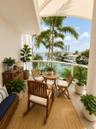 Covered balcony featuring a curved white structural railing and neutral stone-finish flooring