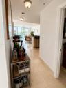 Large-format polished tile flooring, flush-mount ceiling lighting, and floor-to-ceiling glass paneling