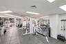 Fitness center featuring large-format tile flooring, recessed panel lighting, and floor-to-ceiling windows