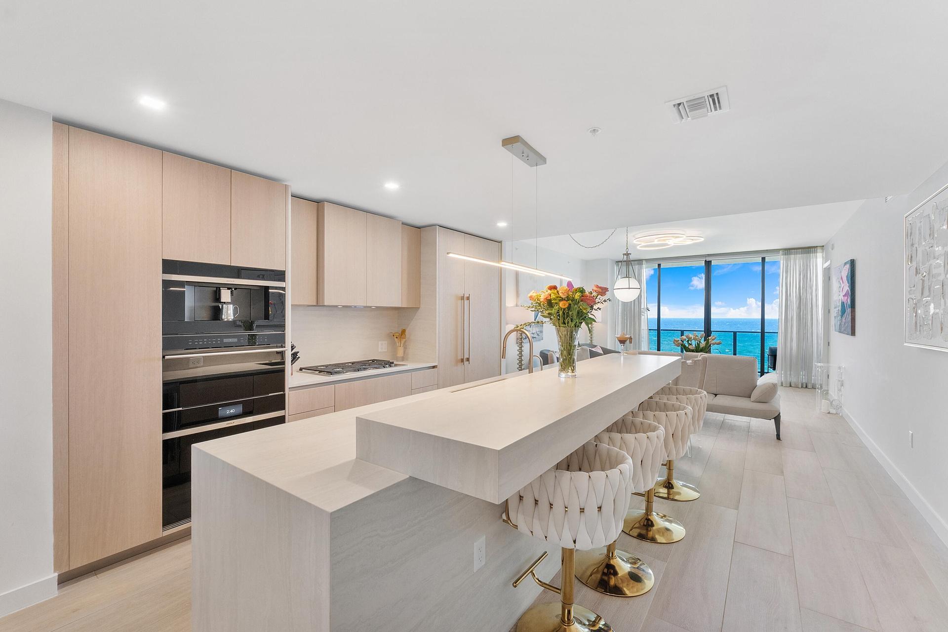 A stunning designer kitchen featuring sleek contemporary cabinetry, premium finishes, and an expansive island, perfectly complemented by breathtaking 