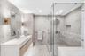 Indulge in a spa-inspired primary bathroom featuring an elegant double vanity, sophisticated finishes, and a spacious glass-enclosed shower for the ul
