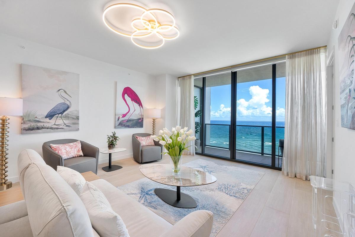 Sophisticated coastal living at its finest, featuring a beautifully appointed living room with modern designer furnishings and a warm, inviting atmosp