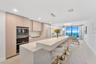A stunning designer kitchen featuring sleek contemporary cabinetry, premium finishes, and an expansive island, perfectly complemented by breathtaking 