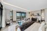 Floor-to-ceiling sliding glass doors, built-in recessed shelving with integrated accent lighting, light-toned wood-finish flooring, and a covered balc