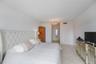 Neutral-toned tile flooring, recessed ceiling lighting fixture, and traditional white interior doors