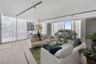 Floor-to-ceiling glass walls, neutral large-format tile flooring, industrial-style track lighting, concrete architectural column, and glass panel rail