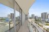 Curved balcony featuring tile flooring, glass panel railings, and floor-to-ceiling sliding glass doors