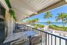 Covered outdoor patio featuring a slatted wood ceiling, metal railing, and direct water exposure