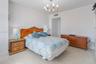 Room featuring tile flooring and a multi-arm metallic chandelier with frosted glass shades