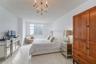 Room featuring large-format tile flooring, a multi-pane window, and an ornate, multi-arm crystal-style chandelier