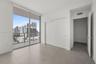 Floor-to-ceiling glass windows, private balcony, large format tile flooring, and built-in sliding door closet