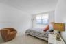Ceramic tile flooring in a diagonal pattern and large window with roller shade