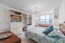 Built-in white storage cabinetry, tiled flooring, multi-pane window, and a decorative overhead light fixture
