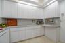 Kitchen featuring flat-panel white cabinetry, solid-surface countertops, integrated recessed lighting, and tile flooring
