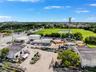 Expansive industrial property featuring multiple detached structures, a metal Quonset-style building, dedicated paved and unpaved storage areas, and d