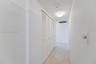Hallway featuring neutral-toned tile flooring and white bi-fold louvered closet doors