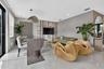 Open-concept living space featuring high-gloss tile flooring, custom floor-to-ceiling built-in shelving, textured wall treatment, and recessed lightin