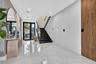Foyer featuring large-format polished tile flooring, a textured stone accent wall, floating black staircase with glass railing, and integrated wood-fi