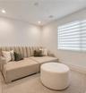 Neutral-toned room featuring recessed ceiling lighting and adjustable window blinds