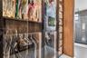 Custom closet system featuring floor-to-ceiling glass panel doors, integrated vertical LED lighting, wood-finish cabinetry, and built-in shelving
