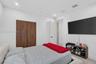 Wood-finish closet doors, recessed lighting, and solid-core interior doors with matte black hardware