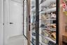 Built-in floor-to-ceiling cabinetry with glass-panel doors, integrated vertical LED strip lighting, wood-finish shelving, and matte black hardware, fe