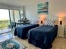 Polished stone flooring, floor-to-ceiling glass sliding doors, and a private balcony with metal railing